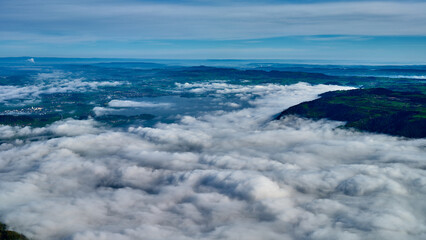 Clouds blanket the valley as the sun rises over the horizon in a serene mountain vista