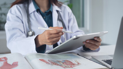 Medical student using digital tablet and laptop in research education. Internship doctor searching the information at doctor's office, medical research. Healthcare and medicine, closeup