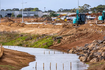 Urban construction site in suburban Australia featuring excavators, utility vehicles, and a newly...