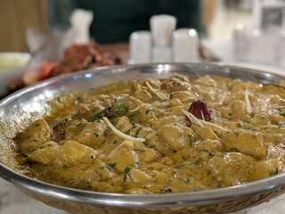 a plate of creamy, hearty stew or curry made with potatoes, vegetables, and spices, served in a...