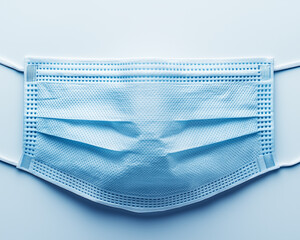Close-up of blue disposable surgical face masks arranged in rows
