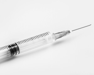 Medical syringe with clear liquid on white background
