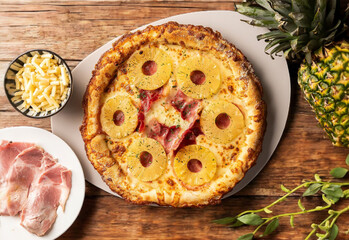 Top view of delicious pineapple pizza on wooden table