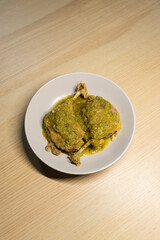 A plate of braised duck leg with green chilli sauce.