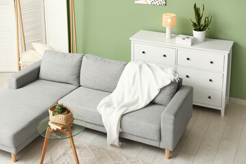 Grey sofa with chest of drawers and glass table in living room