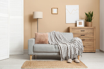 Interior of living room with white folding screen, sofa and lamp