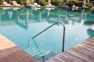 Outdoor swimming pool with steps and rail at resort