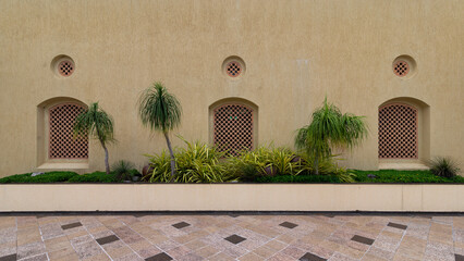 A textured wall features a three decorative lattice panel and circular vents above them. Vibrant...