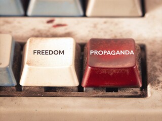 Close up view of an old mechanical keyboard with keys labeled freedom and propaganda