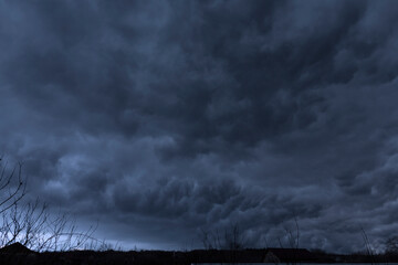 Scary cloudy sky during a storm. Rampant elements. The swirling gray sky.