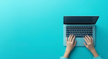 Hands typing on a laptop, teal background