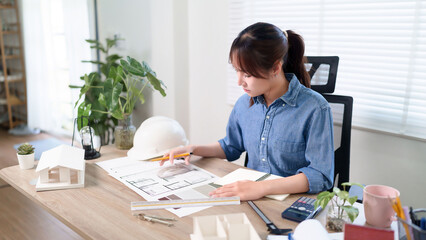 Asian Woman Architect Designs Building Blueprint for Construction Project A Young Female Focus on Architecture Design Building Plans for Home Project