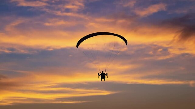 Paraglider soaring in sunset sky silhouette adventure travel concept