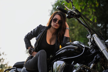 Closeup shot of attractive girl with sunglasses posing on motorcycle 