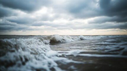 Obraz premium Crashing ocean waves beneath a dramatic overcast sky are seen