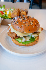 Deep-fried boneless Korean chicken burger with sweet buns. Crispy outside, juicy and succulent inside, smelling delicious.