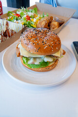 Deep-fried boneless Korean chicken burger with sweet buns. Crispy outside, juicy and succulent inside, smelling delicious.