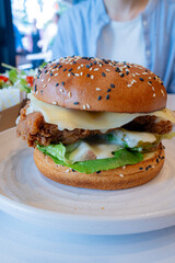 Deep-fried boneless Korean chicken burger with sweet buns. Crispy outside, juicy and succulent inside, smelling delicious.