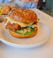 Deep-fried boneless Korean chicken burger with sweet buns. Crispy outside, juicy and succulent inside, smelling delicious.