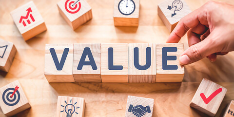 The word VALUE. concept image of strategic value. Putting wood cubes with alphabets and icons. Top view of a wood table