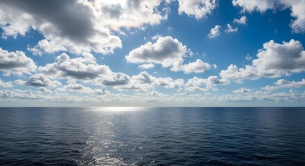 Obraz premium Serene Ocean Vista: A Captivating Seascape Under a Blue Sky Adorned with Puffy White Clouds