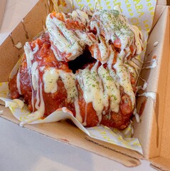 A stack of deep-fried boneless chicken pieces with spicy sauces and mayo. Crispy outside, juicy and succulent inside, smelling delicious.