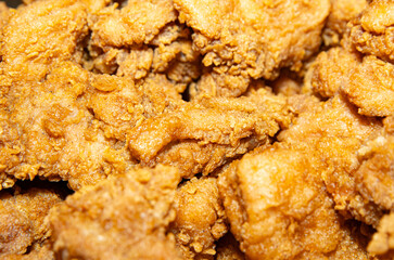 Close-up of a stack of deep-fried boneless chicken pieces. Crispy outside, juicy and succulent inside, smelling delicious.