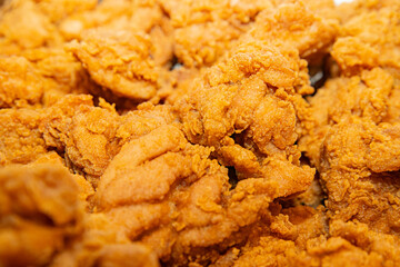 Close-up of a stack of deep-fried boneless chicken pieces. Crispy outside, juicy and succulent inside, smelling delicious.