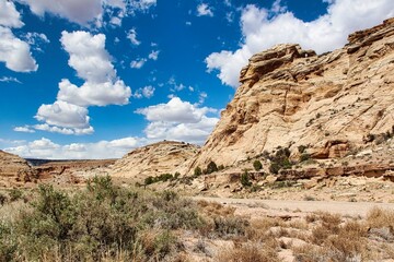 Fototapeta premium White Sandstone Cliffs and Spring Sky above the Dinosaur Track Trail in the Buckhorn Draw, San Rafael Swell in Central Utah.