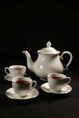 Fototapeta premium Elegant tea set with vintage teapot and cups on black background, teapot, cups, Moscow