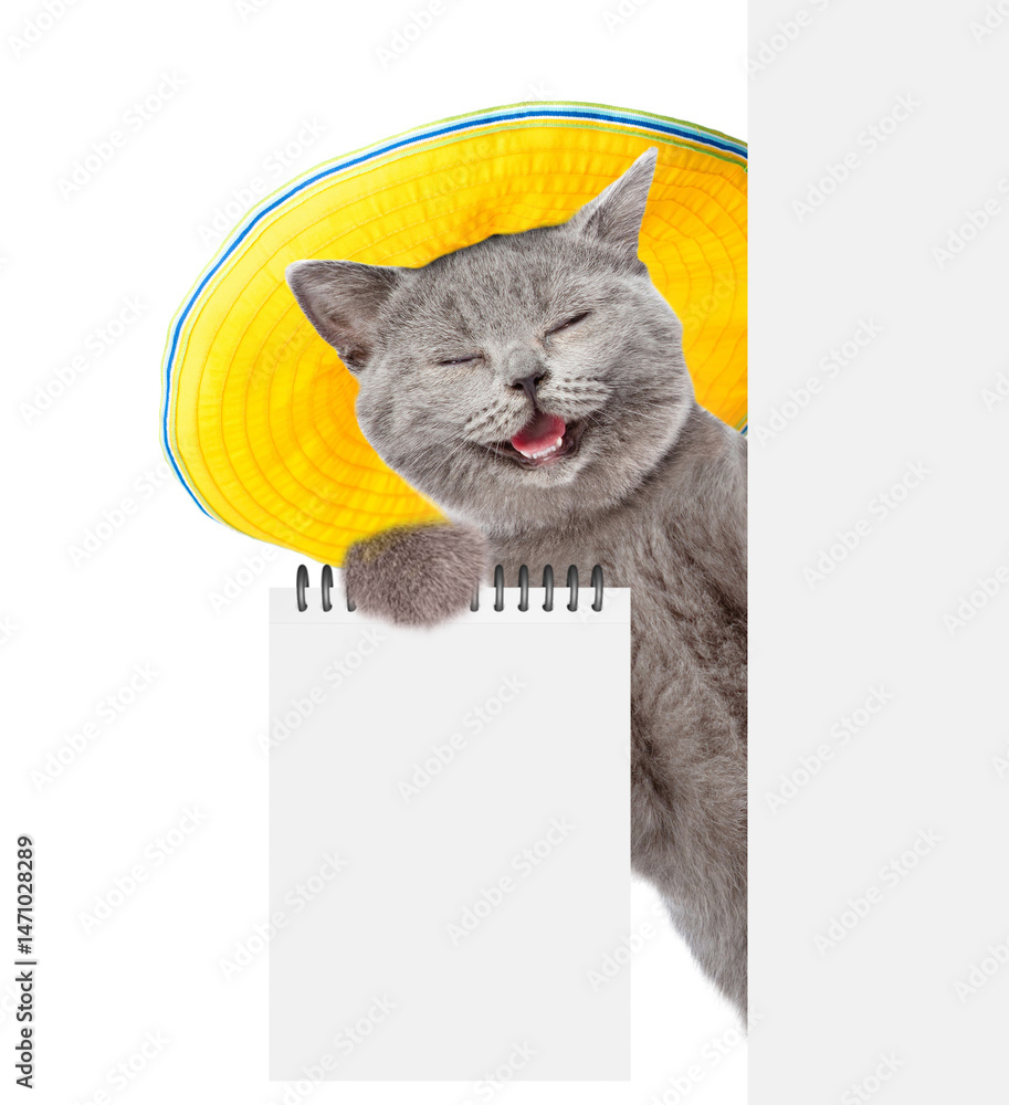 Aufkleber happy cat wearing summer hat looks from behind blank white board and showing blank notepad. isolated