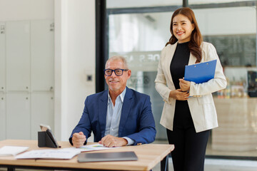 Team of confident business people point to graphs and charts to analyze market data, balance sheet, account, net profit to plan new sales strategies to increase production capacity.	