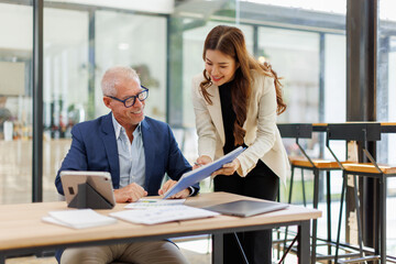 Team of confident business people point to graphs and charts to analyze market data, balance sheet, account, net profit to plan new sales strategies to increase production capacity.	