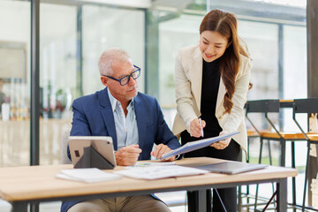 Team of confident business people point to graphs and charts to analyze market data, balance sheet, account, net profit to plan new sales strategies to increase production capacity.	