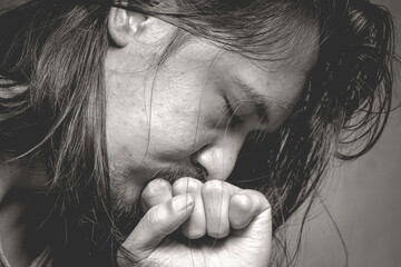 Close-Up of Depressed Man with Hand on Mouth in Thoughtful Pose