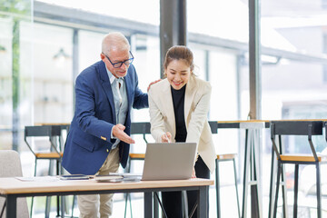 Businessman and Woman Working Together on Laptop in Contemporary Office.Successful Team Meeting with Digital Device in Stylish Office Setting
