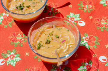 Two bowls of fish in tiger's milk marinate resting on festive tablecloth