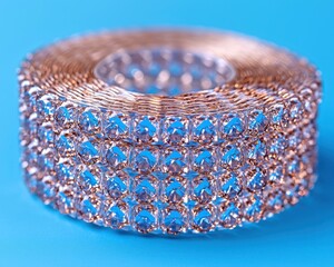 Sparkling decorative ribbon with crystal embellishments on a vibrant blue background