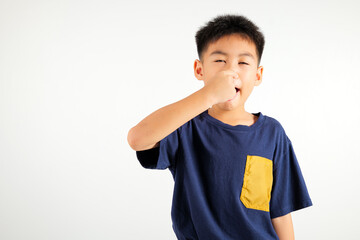 Asian young child unhappy what a smell disgust expression squeezing nose with fingers. Kid boy...