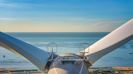 Tall windmill turbines against a clear blue sky, generating renewable energy in the serene Ninh Thuan, Vietnam landscape by the sea. Same with windmill park in the Noordoostpolder Netherlands. © Dong