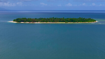 Obraz premium Tropical island surrounded by clear blue water and golden sandy beaches. Alnigkakajaw Island also called Aling island. One of many tropical islands in Surgaio Del Norte Philippines.