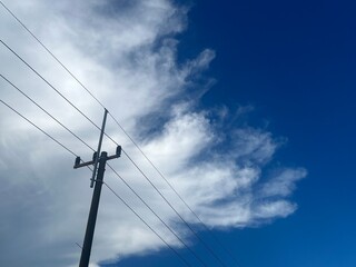 This photo captures a dramatic sky with a mix of wispy white clouds and deep blue background,...