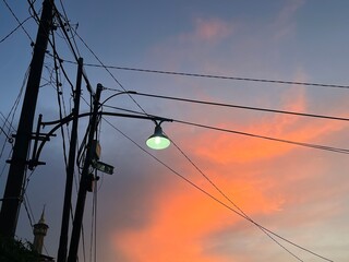 This photo beautifully captures the moment of sunset in an urban neighborhood. The sky is painted...