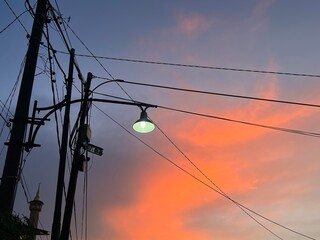 This photo beautifully captures the moment of sunset in an urban neighborhood. The sky is painted...