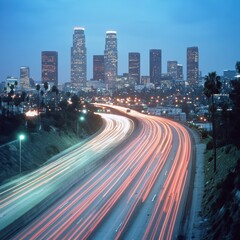 Fototapeta premium Downtown Los Angeles skyline at dusk long exposure of traffic on highway leading to city center California