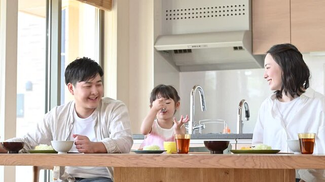 木造の綺麗なお家でご飯を食べる3人の日本人家族　ダイニングで笑顔の食卓の動画