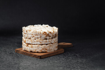 Stacked rice cakes on a wooden board with a dark background