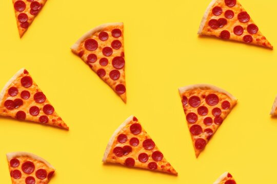 Pepperoni pizza slices pattern on bright yellow background. Fast food concept for menu design, party invitation or National Pizza Day celebration. Top view with copy space.