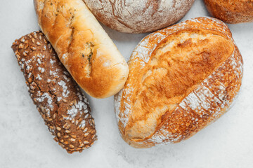 Freshly baked assorted bread on a light surface showcasing diverse textures