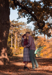 Fototapeta premium young couple in love walking, kissing and having fun in the autumn park